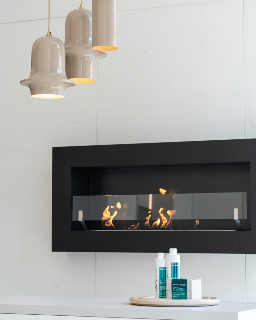 Texte alternatif : Indiquez Agencement haut de gamme pour salon de coiffure avec cheminée design et luminaires suspendus - Groupe CAC